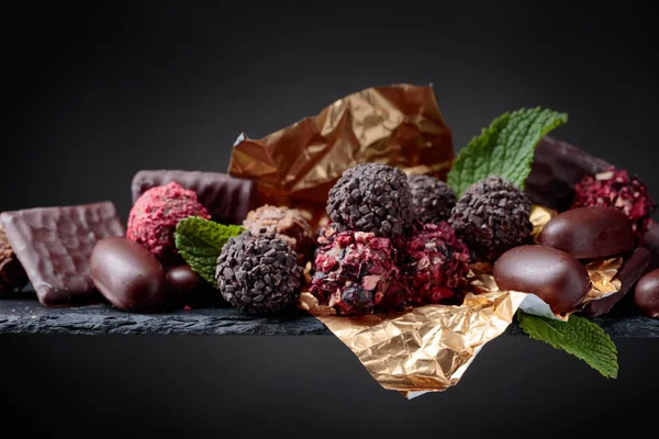 Various Chocolates Mint Leaves Black Background Copy Space — Stock Photo, Image