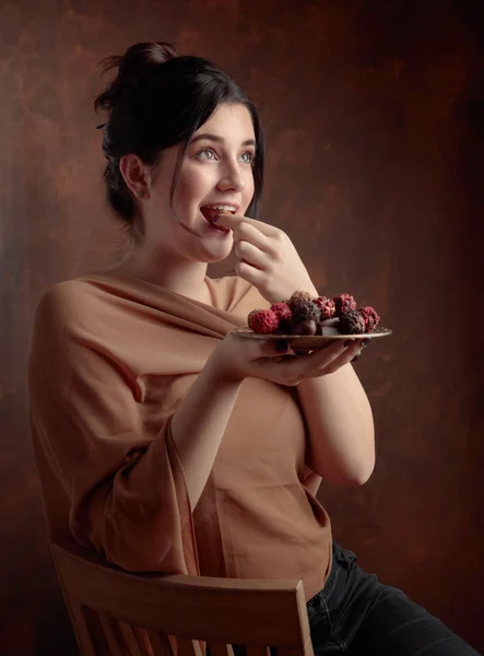 チョコレートやキャンディーを持つ美しい少女の肖像画 — ストック写真