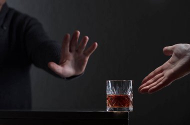 Adam bir hareketi ile alkol reddediyor. Alkolizm konusunda kavramsal görüntü. Metniniz için kopya alanı.