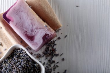 Eflatun Beyaz ahşap zemin üzerinde doğal organik sabun Bar. El yapımı Sabun yapımı. Spa Ürünleri ve cilt bakım kavramı. Kopya alanı.