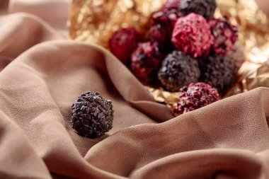 Bir Bej Saten üzerinde çeşitli çikolatalar. Seçici odak.