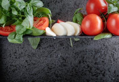 Mozzarella fesleğen ve bir arka plan üzerinde domates ile eski duvar gri. Metniniz için kopya alanı.