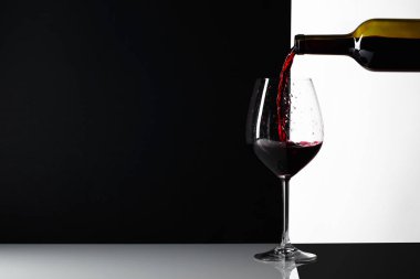 Kırmızı şarap bardağa dökülür..