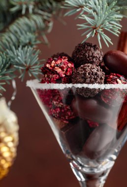  Kadehte çeşitli çikolatalı şekerler var. Tarçın çubukları ve çikolatalı Noel süsü. Noel tatili dolu bir hayat. 