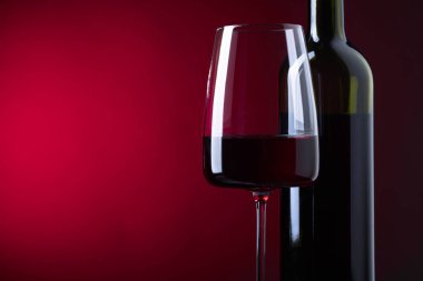 Cam ve karanlık bir arka plan üzerinde kırmızı şarap. Metniniz için kopya alanı.