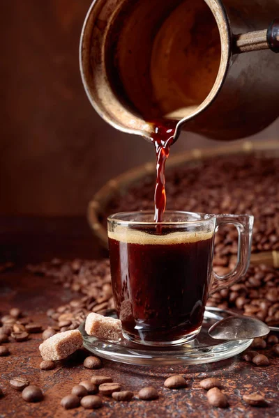 Café Preto Derramado Uma Pequena Xícara Vidro Uma Cafeteira Cobre — Fotografia de Stock