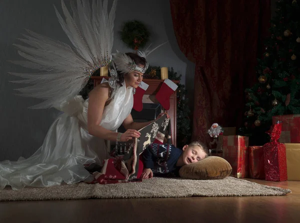 Спящий Мальчик Елкой Ангел Хранитель Покрывающий Одеялом Ангел Белом Платье — стоковое фото