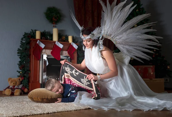 Спящий Мальчик Елкой Ангел Хранитель Покрывающий Одеялом Ангел Белом Платье — стоковое фото