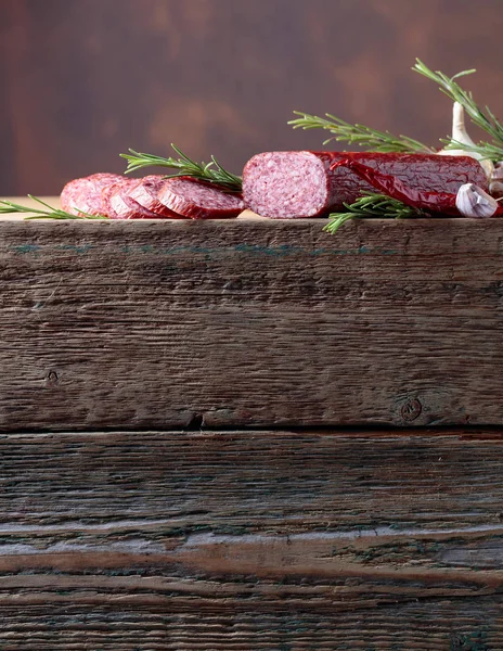 在一张旧木桌上的烟熏香肠 香肠配迷迭香 大蒜和胡椒粉 自然木制的背景 复制文本的空间 — 图库照片