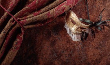 Eski maskeli balo Venedik karnaval maskesi ile tüyleri ve rhinestones kahverengi duvar bir arka plan üzerinde. Kopya alanı.