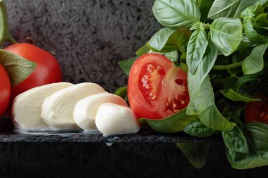 Mozzarella fesleğen ve bir arka plan üzerinde domates ile eski duvar gri. Metniniz için kopya alanı.