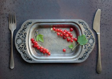 Redcurrants metal çanak çatal ve bıçak üzerinde. Sağlıklı beslenme, diyet ve antioksidan için kavram. Üstten görünüm.