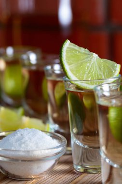 Küçük bardak tekila ve limon dilimleri.