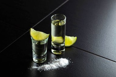 Küçük bardak tekila ve limon dilimleri.