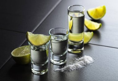 Küçük bardak tekila ve limon dilimleri.