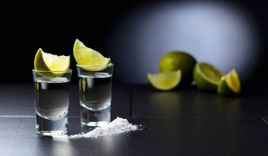 Küçük bardak tekila ve limon dilimleri.