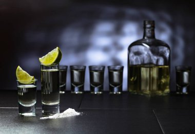 Küçük bardak tekila ve limon dilimleri.