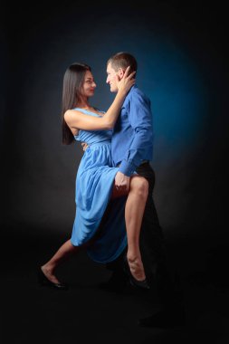 Genç güzel kadın uzun mavi elbise ve tango dans mavi tişörtlü adam. Kaç stüdyoda dans aşk içinde.