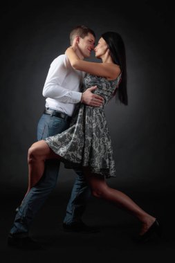Genç güzel kadın elbise ve tango dans Beyaz tişörtlü adam. Kaç stüdyoda dans aşk içinde.