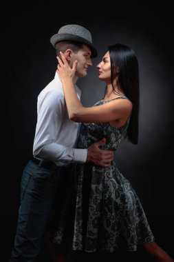Genç güzel kadın elbise ve tango dans Beyaz tişörtlü adam. Kaç stüdyoda dans aşk içinde.