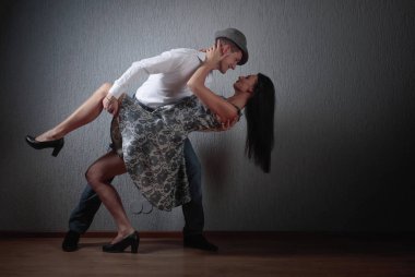 Genç güzel kadın elbise ve tango dans Beyaz tişörtlü adam. Kaç stüdyoda dans aşk içinde.
