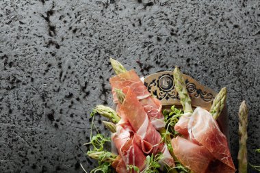 Prosciutto ile tere salatası metal bir arka plan üzerinde sarılı kuşkonmaz. Üstten görünüm, metniniz için kopya alanı. 