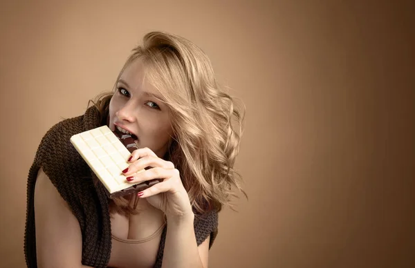 幸せな若い美しい女性のチョコレートを食べるします 若い金髪の女性はチョコレートを食べると楽しい自然化粧品 — ストック写真