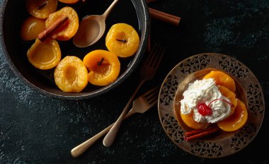 Tarçın, krem ve karanlık bir arka plan, üstten görünüm kiraz şeftali tatlısı.