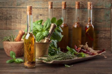 Zeytin yağı ile farklı baharatlar ve otlar eski ahşap bir masa üzerinde. Sağlıklı organik gıda.