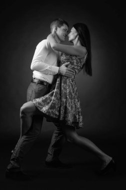 Genç güzel kadın elbise ve tango dans Beyaz tişörtlü adam. Kaç stüdyoda dans aşk içinde.
