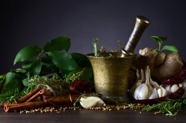 Farklı otlar ve baharatlar ile zencefil ahşap bir masa üzerinde. Baharat eski pirinç havan topu .