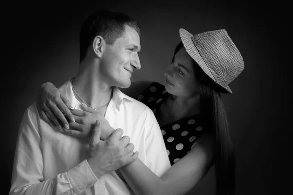 Young beautiful woman in polka dot dress and man in white shirt. Couple in love. Black and white.