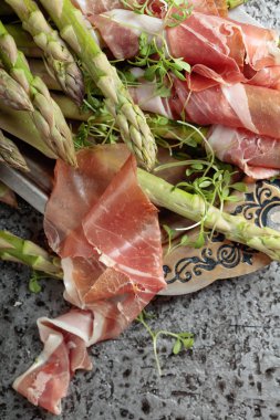 Prosciutto ile tere salatası metal bir arka plan üzerinde sarılı kuşkonmaz. Üstten görünüm. 