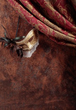Eski maskeli balo Venedik karnaval maskesi ile tüyleri ve rhinestones kahverengi duvar bir arka plan üzerinde. Kopya alanı.