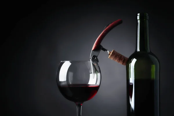 ガラスと黒い背景に栓抜きと赤ワインのボトル テキストのコピー スペース — ストック写真