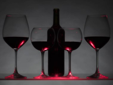 Gözlük ve karanlık bir arka plan üzerinde kırmızı şarap şişe.