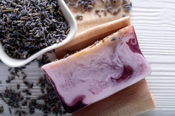 Eflatun Beyaz ahşap zemin üzerinde doğal organik sabun Bar. El yapımı Sabun yapımı. Spa Ürünleri ve cilt bakım kavramı. 