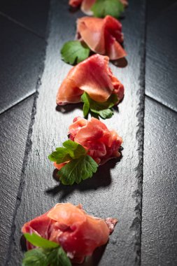Jamon serrano maydanoz siyah bir tablo ile. Sağlıklı organik gıda . 
