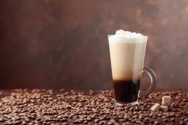 Kahve içecek bir kokteyl ile krem ve kahverengi bir arka plan üzerinde kahverengi şeker parçaları. Metniniz için kopya alanı.