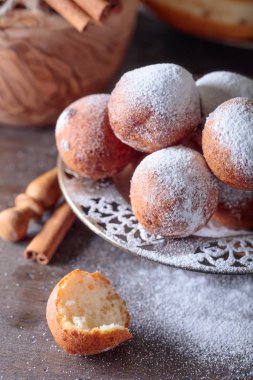 Tatlı çörek, tarçın ve eski ahşap bir masa üzerine pudra şekeri.