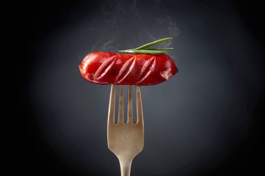 Biberiye çatal üzerinde ızgara sosis. Siyah arka plan, kopya alanı. 