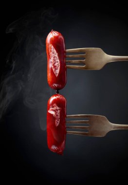 Çatalda ızgara sosis. Siyah arkaplan, boşluğu kopyala. 