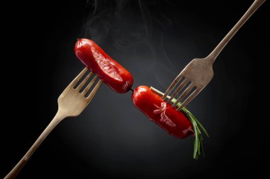 Rosemary bir çatal ile ızgara sosis. Siyah arka plan, kopya alanı. 