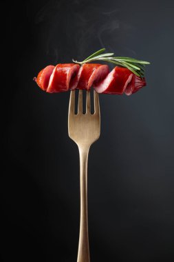 Biberiye çatal üzerinde ızgara sosis. Siyah arka plan, kopya alanı. 
