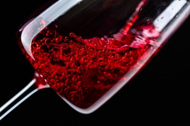 Kırmızı şarap şarap cam içine siyah bir arka plan üzerine dökülür varlık.