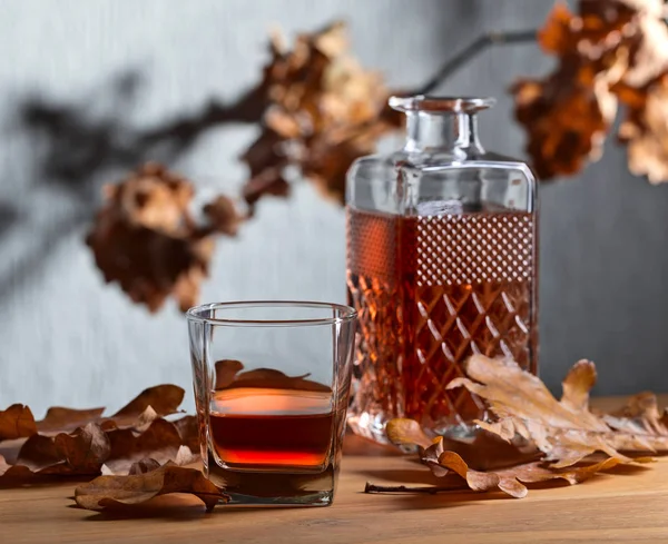 Whiskey Und Getrocknete Eichenblätter Auf Einem Alten Holztisch — Stockfoto