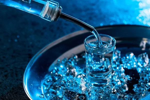 Wódka Przelewa Się Szklanki Zapalił Niebieskim Podświetleniem Schłodzona Wódka Kawałkami — Zdjęcie stockowe
