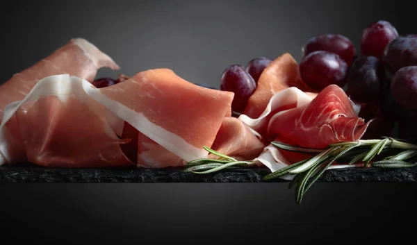 Prosciutto Con Uvas Romero Sobre Fondo Negro Primer Plano Espacio —  Fotos de Stock