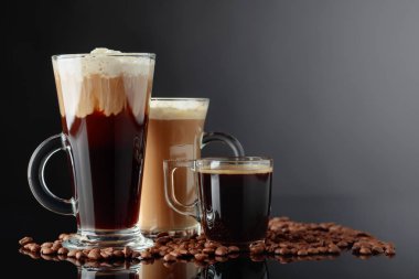 Siyah yansıtıcı arka planda çeşitli kahve içiyor. Kopya alanı.