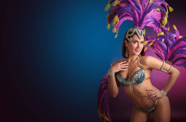 Güzel esmer bir karnaval kılık rhinestones ve doğal tüyleri ile. Güzel profesyonel makyaj, mükemmel saç. Çekici kadın kabare dansçı mavi ve mor eşarplı seksi kostüm. Kopya alanı.